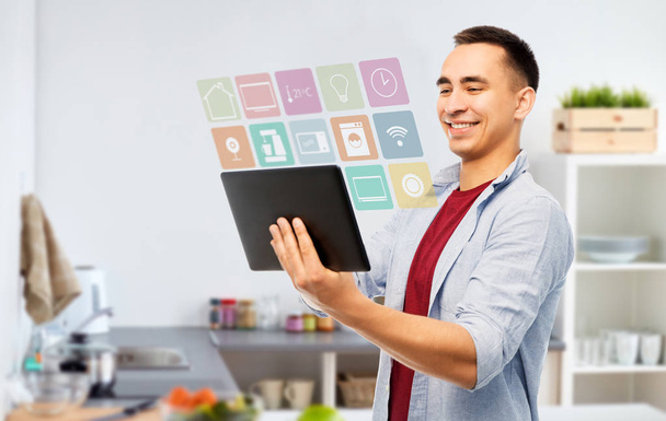 happy young man with tablet computer in kitchen - Фото, зображення