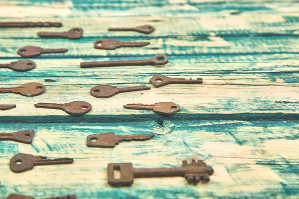Coleção de muitas chaves retro velhos diferentes em ordem no conceito de fundo rústico de madeira. Fundo decorativo criativo. Deitado. Espaço para cópia. Vista superior
 - Foto, Imagem