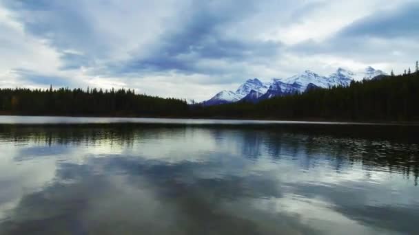 Herbert Gölü timelapse kar dağ ve orman yansıması ile bulutlu bir günde Banff Ulusal Parkı'nda panoramik görünümü kaydırma. - Video, Çekim