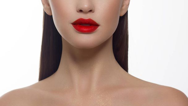 Cosmetics, makeup and trends. Bright lip gloss and lipstick on lips. Closeup of beautiful female mouth with red lip makeup. Beautiful part of female face. Perfect clean skin in red light - Foto, Imagen
