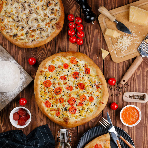 vista superior de dos pizzas cocidas sobre mesa de madera
 - Foto, Imagen
