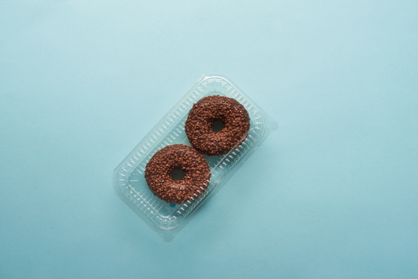 vista superior de sabrosas rosquillas de chocolate sobre fondo azul
  - Foto, Imagen