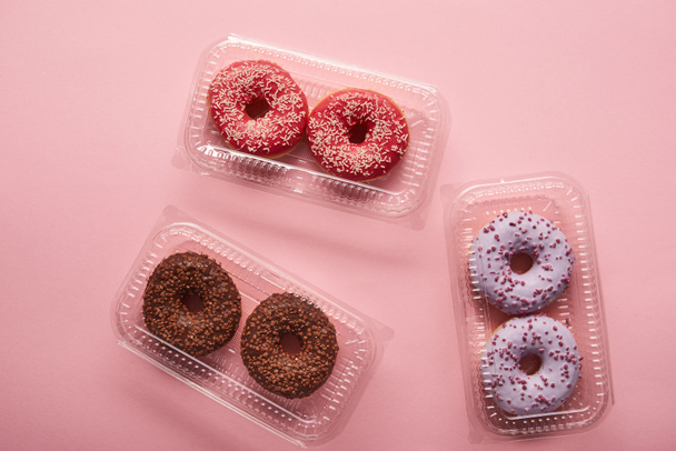 ylhäältä näkymä maukkaita donitseja vaaleanpunainen tausta
  - Valokuva, kuva