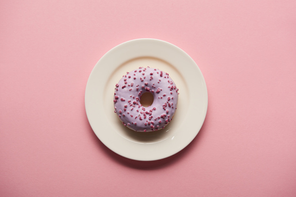 top view of tasty donut on white plate on pink background - Foto, imagen