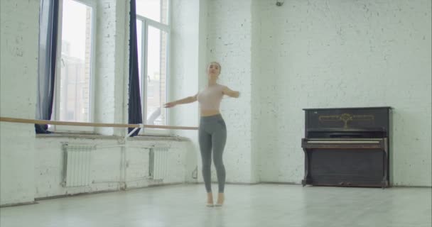 Ballerina performing soutenu in dance studio - Filmati, video