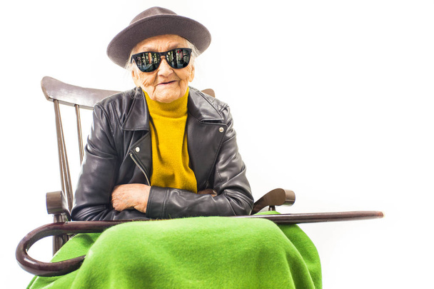 Old woman with hat and sunglasses sitting on the chair - Photo, Image