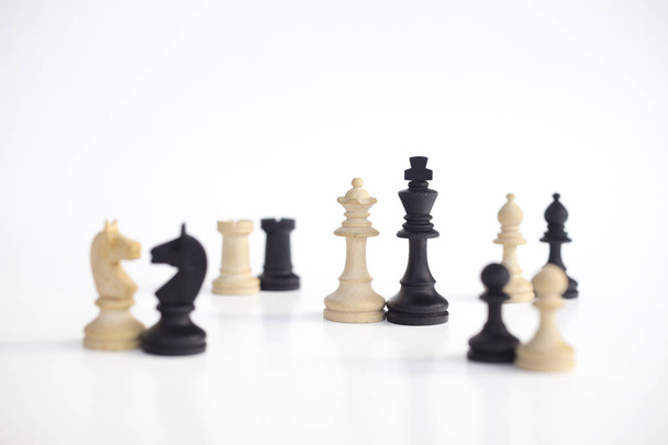 La reina blanca y el rey negro, tradicionalmente confrontados en el juego de ajedrez, están juntos. Imagen en fondo blanco aislado
. - Foto, Imagen