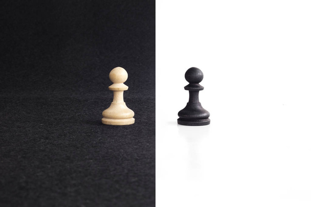 Пара піонових шахових фігур зіткнулася з протилежностями на чорно-білому тлі
. - Фото, зображення