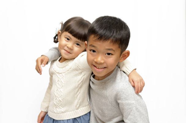 日本の兄と妹 (9 歳の男の子と 4 年古い女の子を肩の周りに腕を置く) - 写真・画像