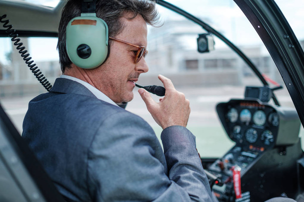 Businessman behind steering wheel of his helicopter - Zdjęcie, obraz