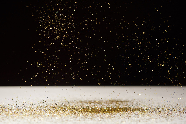white table with bright sparkles isolated on black  - 写真・画像