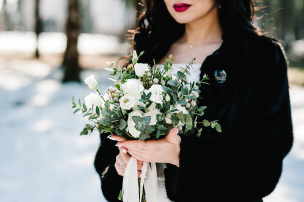 Close view of bride holding elegant wedding bouquet in hands - Foto, afbeelding