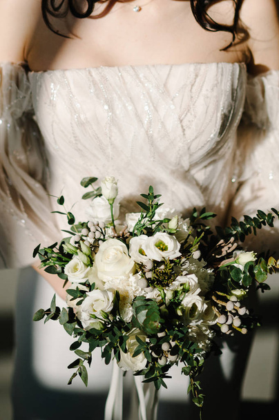 Close view of bride holding elegant wedding bouquet in hands - Foto, imagen