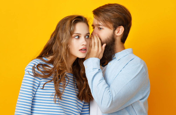 Paar junger emotionaler Menschen Mann und Frau auf gelbem Hintergrund - Foto, Bild