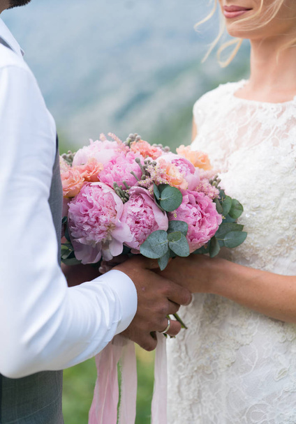 couple holding a wedding bouquet of pink peonies - Foto, Imagem