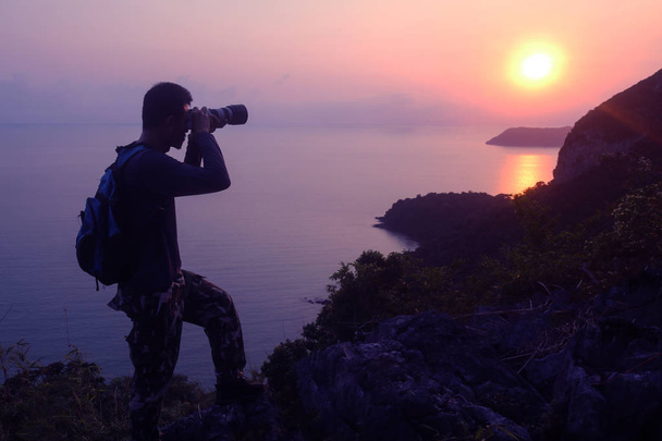 Silhouette viola dell'uomo arrampicata su roccia, Fotografo sulla montagna all'alba, Isola dell'arcipelago in Thailandia
 - Foto, immagini