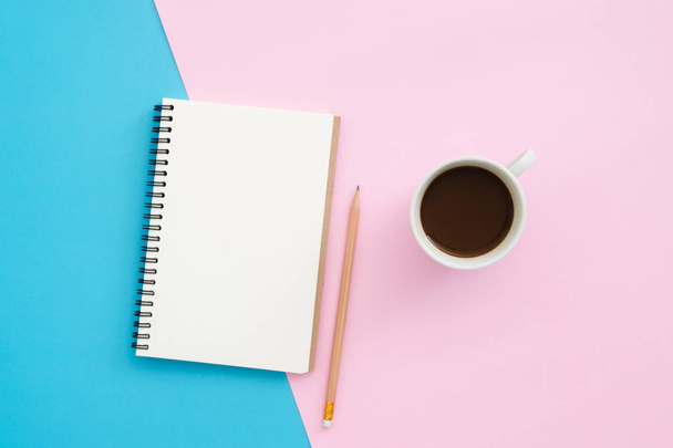 Creative flat lay photo of workspace desk. Top view office desk with pencil, notebook and coffee cup on blue pink color background. Top view with copy space, flat lay photography. - Photo, Image