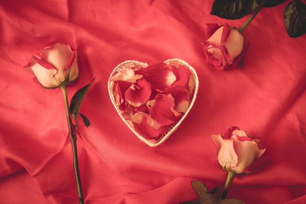 red rose petal in heart shape with red background - Foto, Imagem