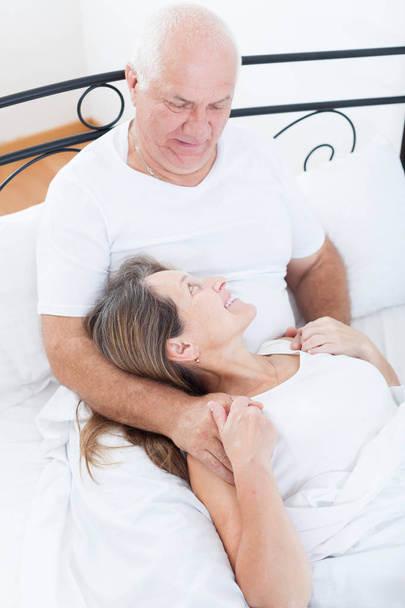 Mature man and woman on   bed in   bedroom. - Foto, Bild