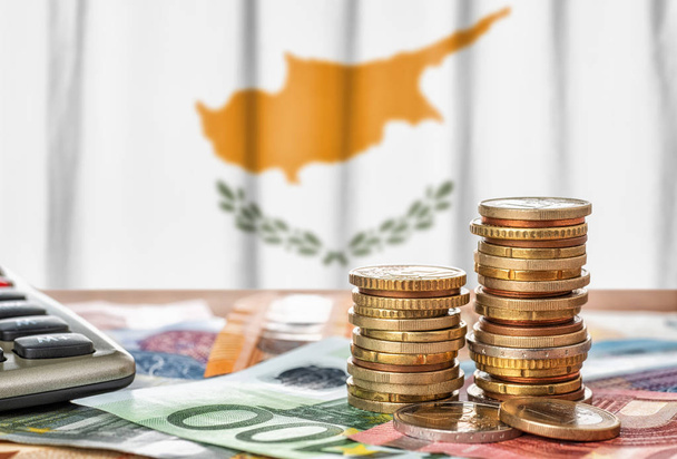 Banconote e monete in euro davanti alla bandiera nazionale di Cipro
 - Foto, immagini