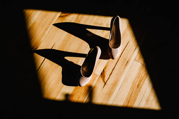 Стильне елегантне класичне лаковане бежеве взуття на дерев'яній поверхні
 - Фото, зображення