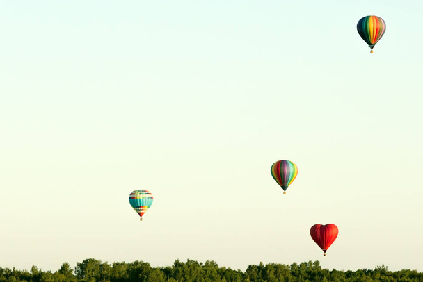 in einem Ballon fliegen. Vier Kugeln fliegen über den Wald gegen den wolkenlosen Himmel - Foto, Bild