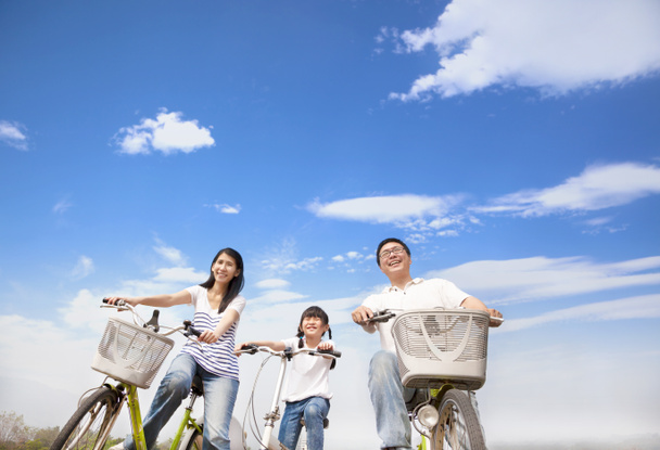 gelukkig familie fietsten met wolk achtergrond - Foto, afbeelding