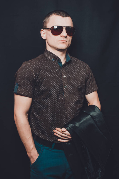 portrait of a sexy man dressed in a black shirt and brown sunglasses 2018 - Photo, Image
