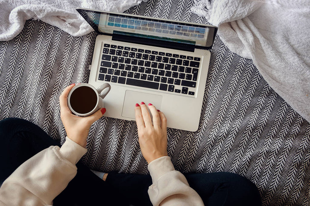 Девушка работает за ноутбуком и пьет черный кофе.
. - Фото, изображение