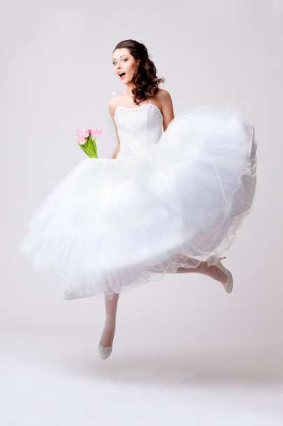 Beautiful bride jumping in studio - Photo, image