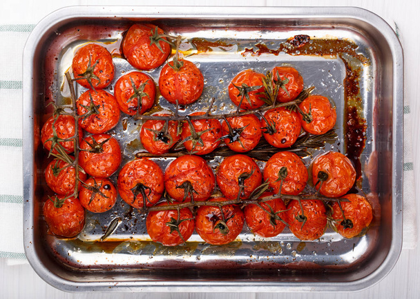 Cherry tomaten op de wijnstok geroosterd met kruiden en balsamico azijn. Bovenaanzicht. - Foto, afbeelding