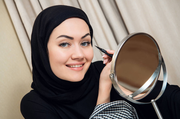 Lächelnde junge Frau mit Make-up und Hijab - Foto, Bild