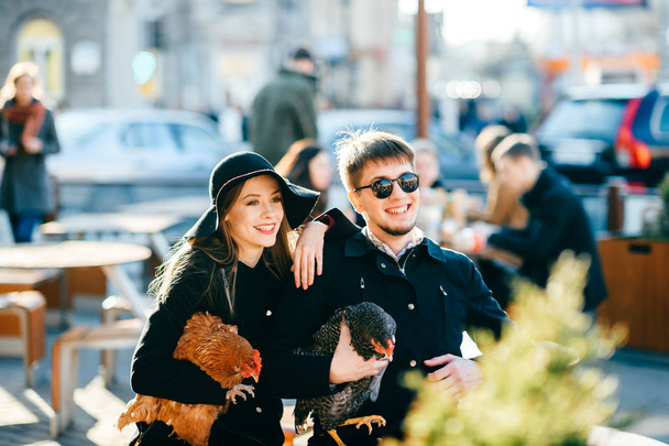stylish couple with domestic chicken on street - Photo, Image