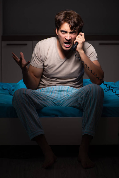 Giovane uomo che parla al telefono a letto
 - Foto, immagini