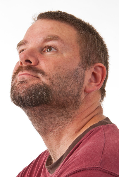 Un hombre caucásico sin afeitar en vista de perfil mirando hacia la izquierda de la cámara
 - Foto, imagen
