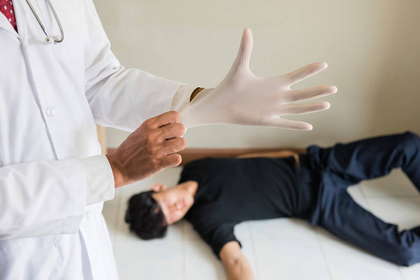 Medical examiner wear rubber glove before performing autopsy or postmortem of death man by overdose. Drug addiction and social issue for teenager, student, and worker. - Photo, Image