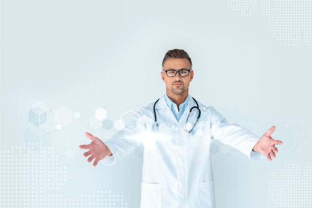 knappe dokter in glazen met stethoscoop op schouders staan met open armen met innovatie technologie interface - Foto, afbeelding