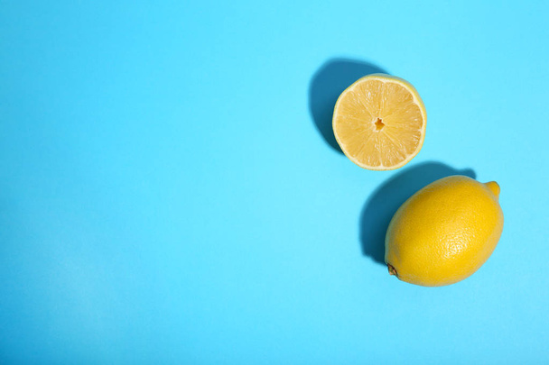 Lemon and half of lemon on blue background. Tropical fruit. - Fotoğraf, Görsel