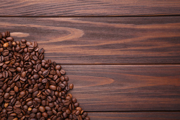 Coffee beans on brown wooden background - Fotó, kép