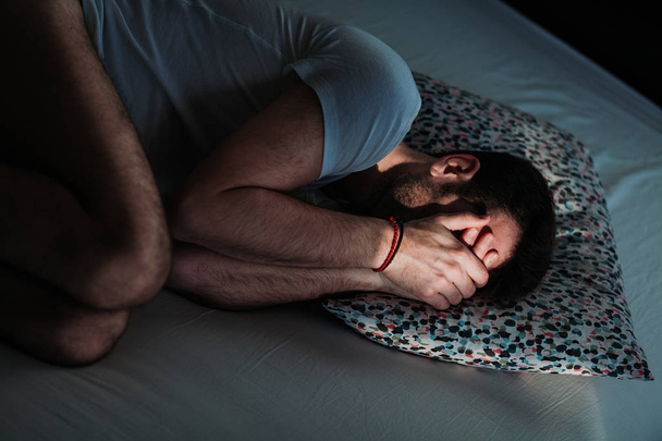 Jeune homme déprimé dans la douleur sur le lit
 - Photo, image