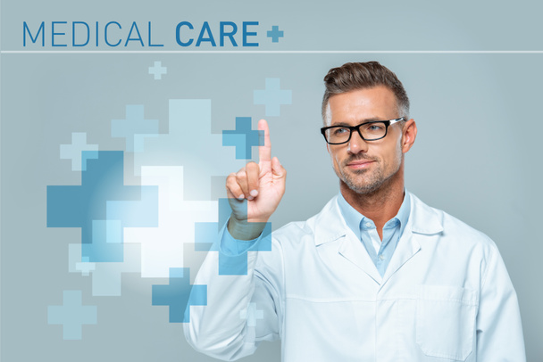 handsome scientist in white coat and glasses touching medical care interface in air isolated on grey, artificial intelligence concept - Photo, Image