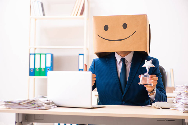 Happy man employee with box instead of his head - Foto, Imagem