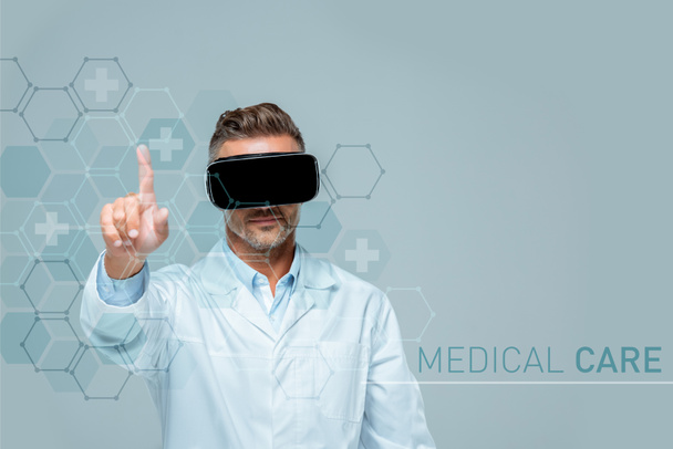 scientist in virtual reality headset touching medical care interface with finger isolated on grey, artificial intelligence concept - Photo, Image