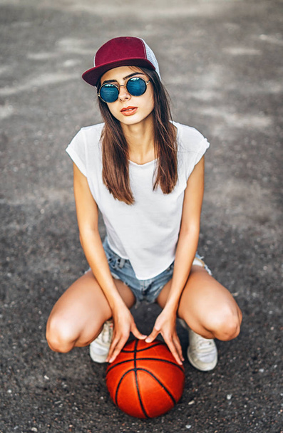 Pretty young sporty girl with basketball ball outdoor - Foto, Imagem