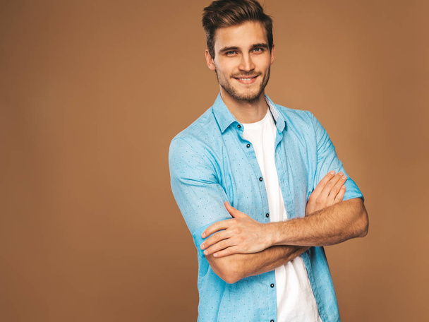 Portrait of handsome smiling stylish hipster lumbersexual businessman model dressed in jeans clothes. Fashion man. Posing on golden background - Fotoğraf, Görsel