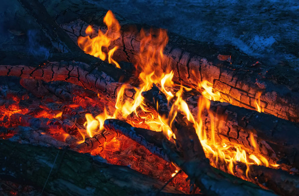 branden sintels in de donkere close-up weergave, rode gestructureerde achtergrond - Foto, afbeelding