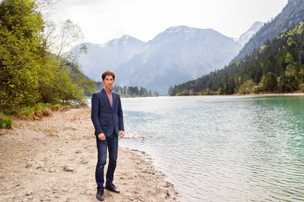 Descanse en un lago de montaña cerca de Neuschwanstein. hombre caminando cerca del lago
 - Foto, imagen