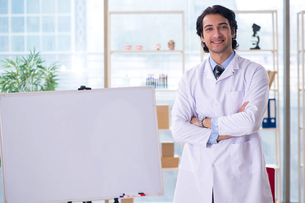 Young handsome doctor in front of whiteboard  - Photo, Image