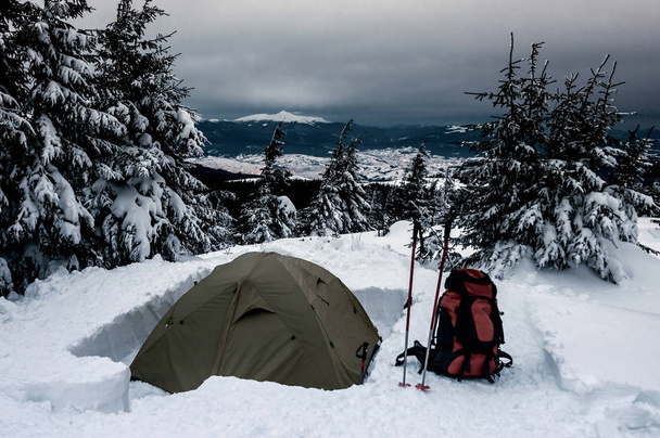 Zimowy kemping w górach. Namiot i plecak na śniegu - Zdjęcie, obraz