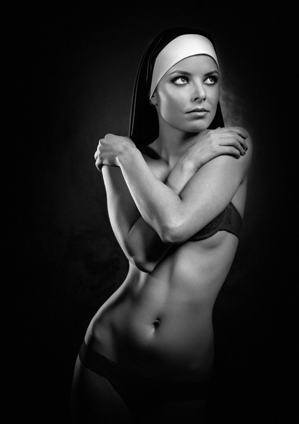 Sexy young nun posing indoors, black and white photo - Fotó, kép